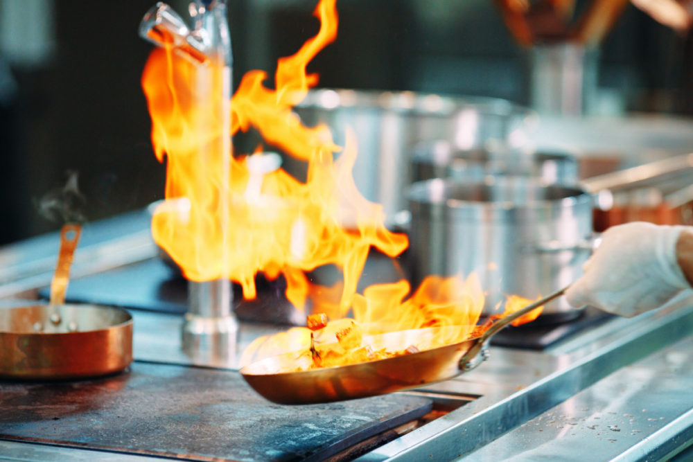 Chef cooking vegetables in wok pan. Shallow dof.